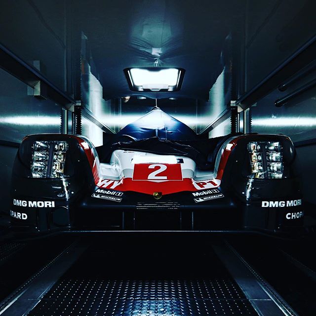 A porsche race car with the number 2 on the hood is inside a truck.