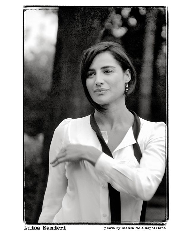 Black and white portrait of Italian actress Luisa Ranieri in a white blouse.