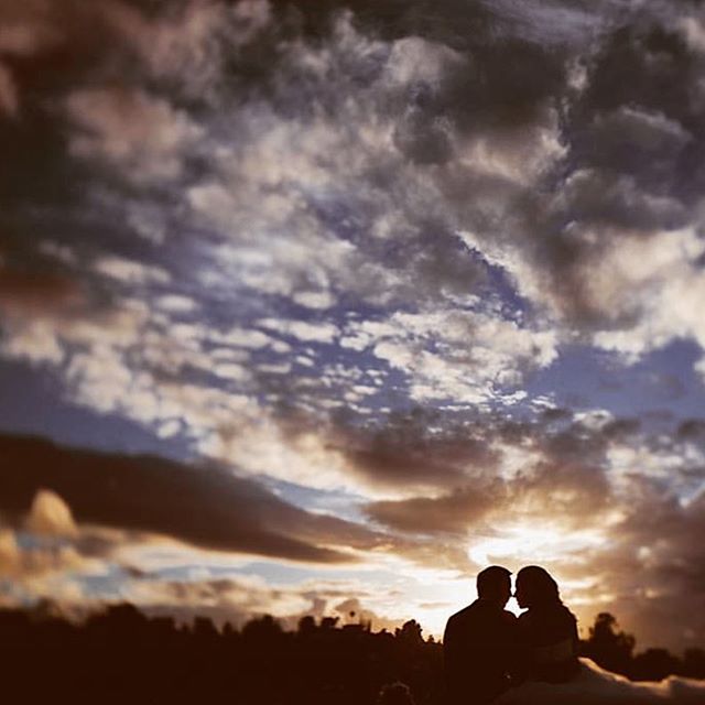 A couple silhouetted against a dramatic sunset, evokes love, romance and intimate moments.