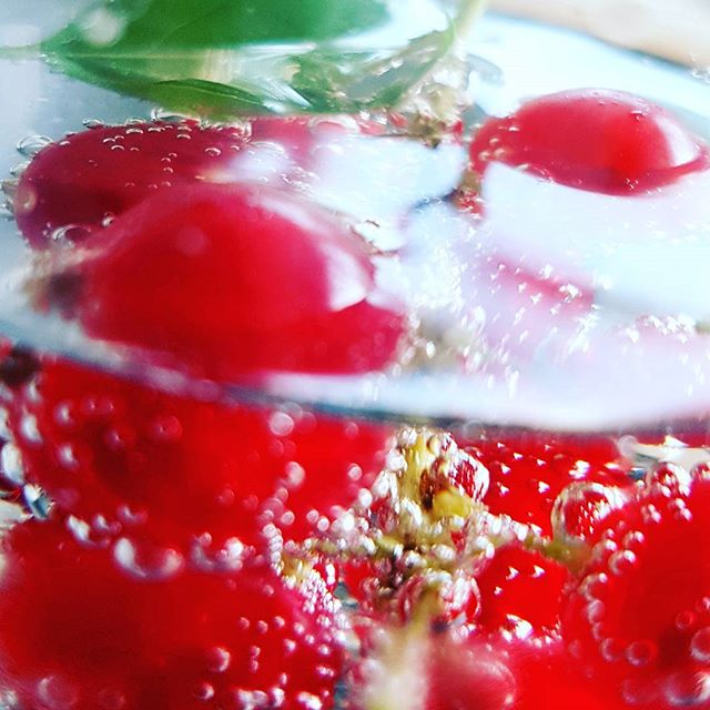 A close-up showcases cherries in sparkling water, highlighting their vibrant red hue and refreshing essence for a lively beverage.