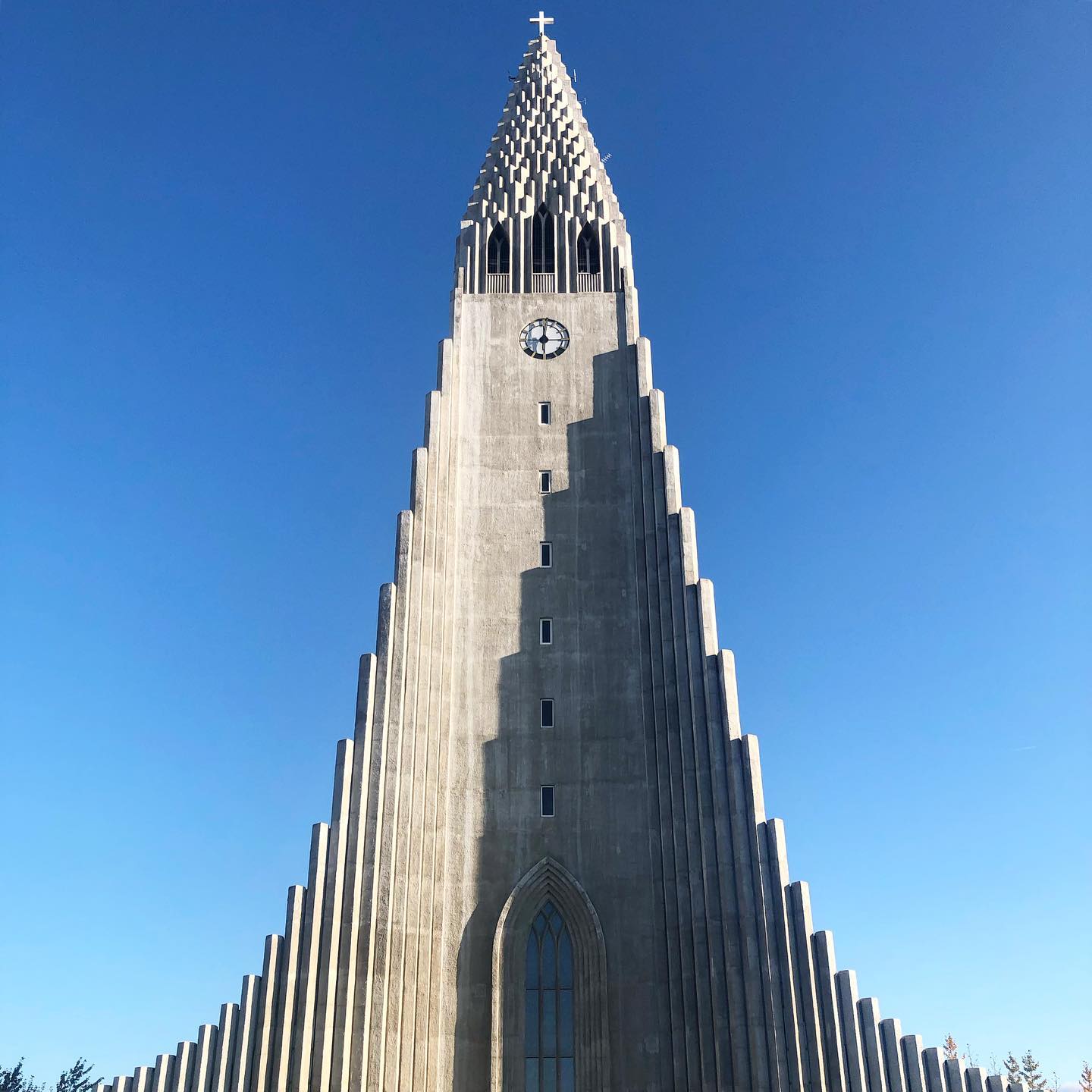 A low-angle view of Hallgrímskirkja church in Reykjavik, Iceland, against a clear blue sky.