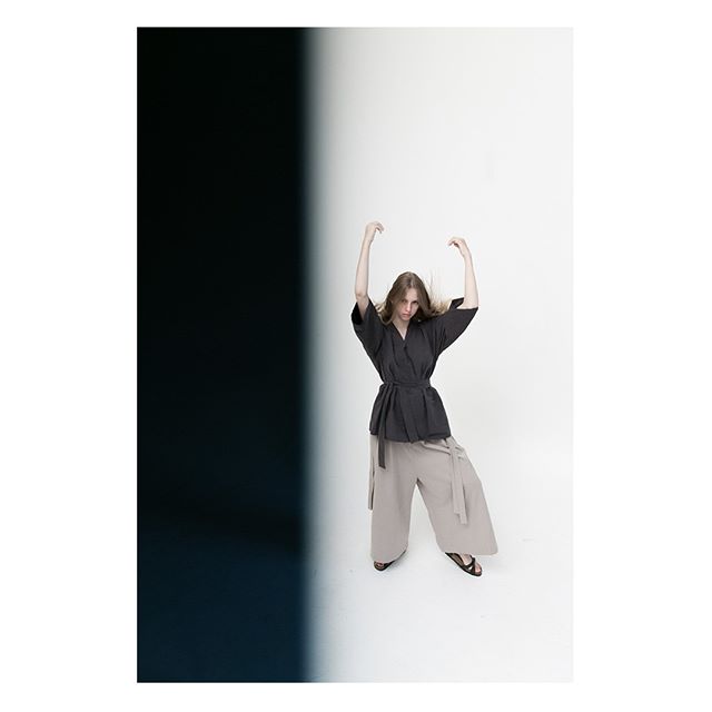 A woman strikes a pose in neutral tones, styled in contemporary, relaxed separates against a minimalist backdrop.