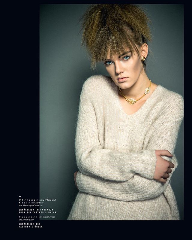 A model poses in a cozy sweater and gold necklace for a fashion editorial shoot.