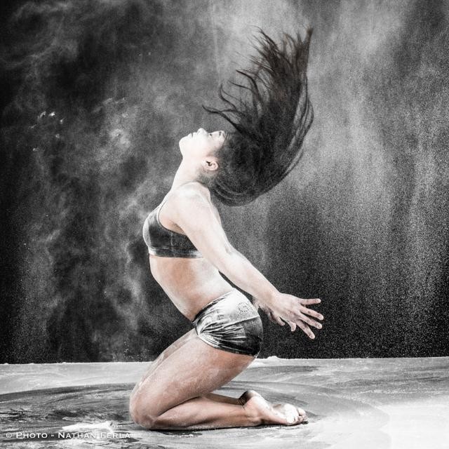 An athletic woman in action, captured in black and white with a dynamic pose and expressive movement.