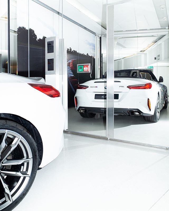 A sleek white BMW convertible is on display in a modern, well-lit showroom.