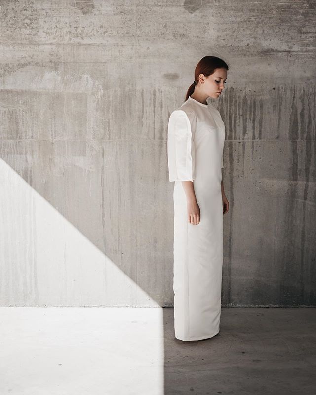 minimalist-white-dress-woman-concrete-wall