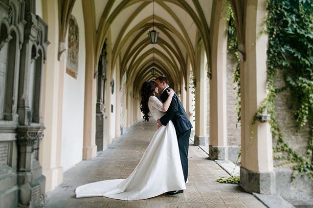 A bride and groom share a kiss in a stunning courtyard, perfect for wedding or travel related marketing.