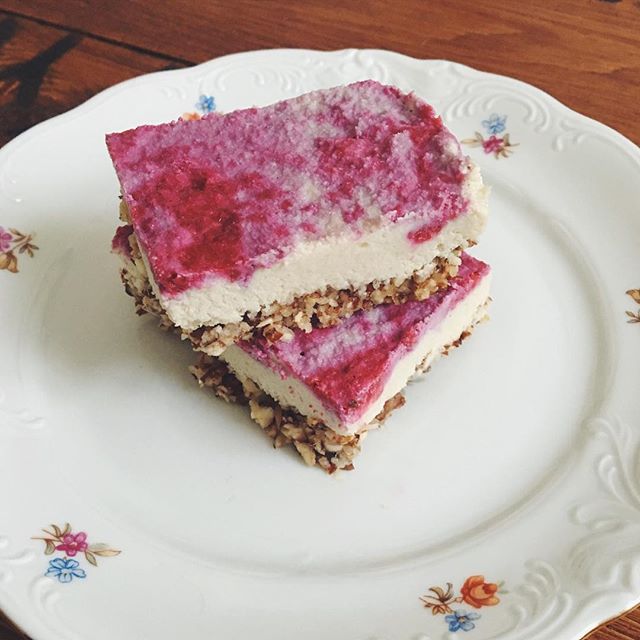 Two slices of a colorful dessert cake are stacked on a decorative plate.