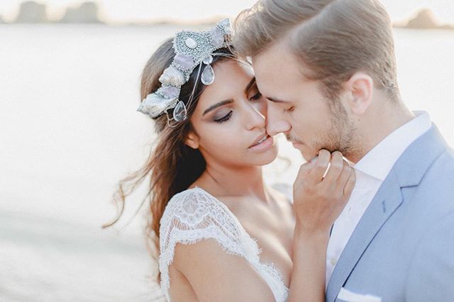A bride and groom share an intimate moment on the beach, perfect for wedding or romance-themed content.