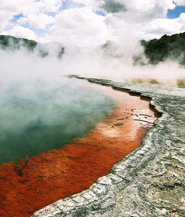Scenic view of the Champagne Pool in Waiotapu, New Zealand, showcasing its unique geothermal landscape and vibrant colors.
