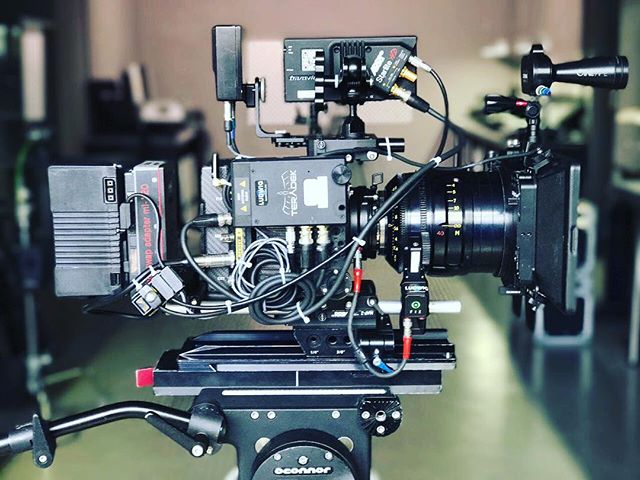 Professional film camera setup for video production with accessories and equipment on a dolly.