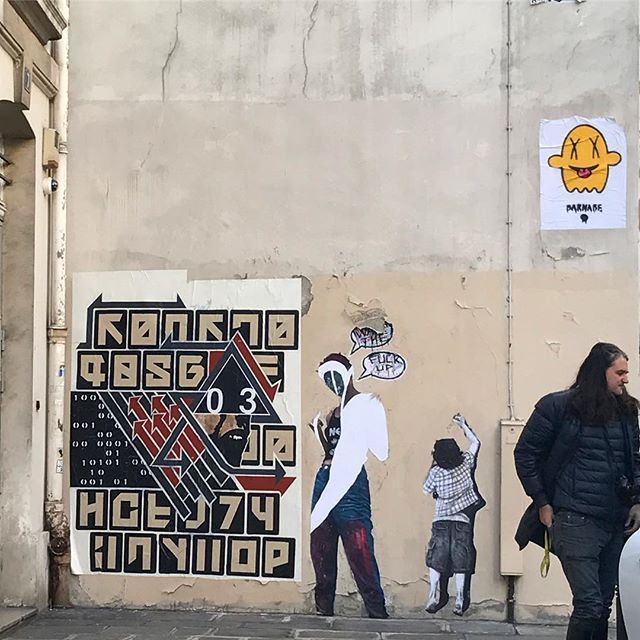Urban street art on a building wall featuring colorful graffiti and posters, capturing the essence of city culture.