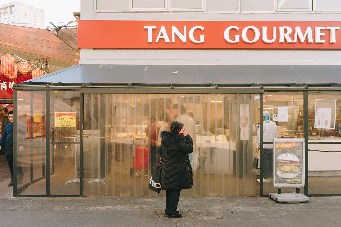 A woman stands outside Tang Gourmet restaurant in the city.