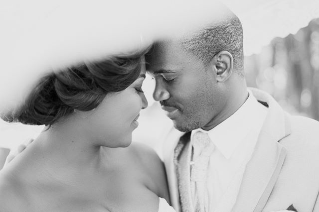 A bride and groom intimately embrace in a close-up black and white wedding photo.