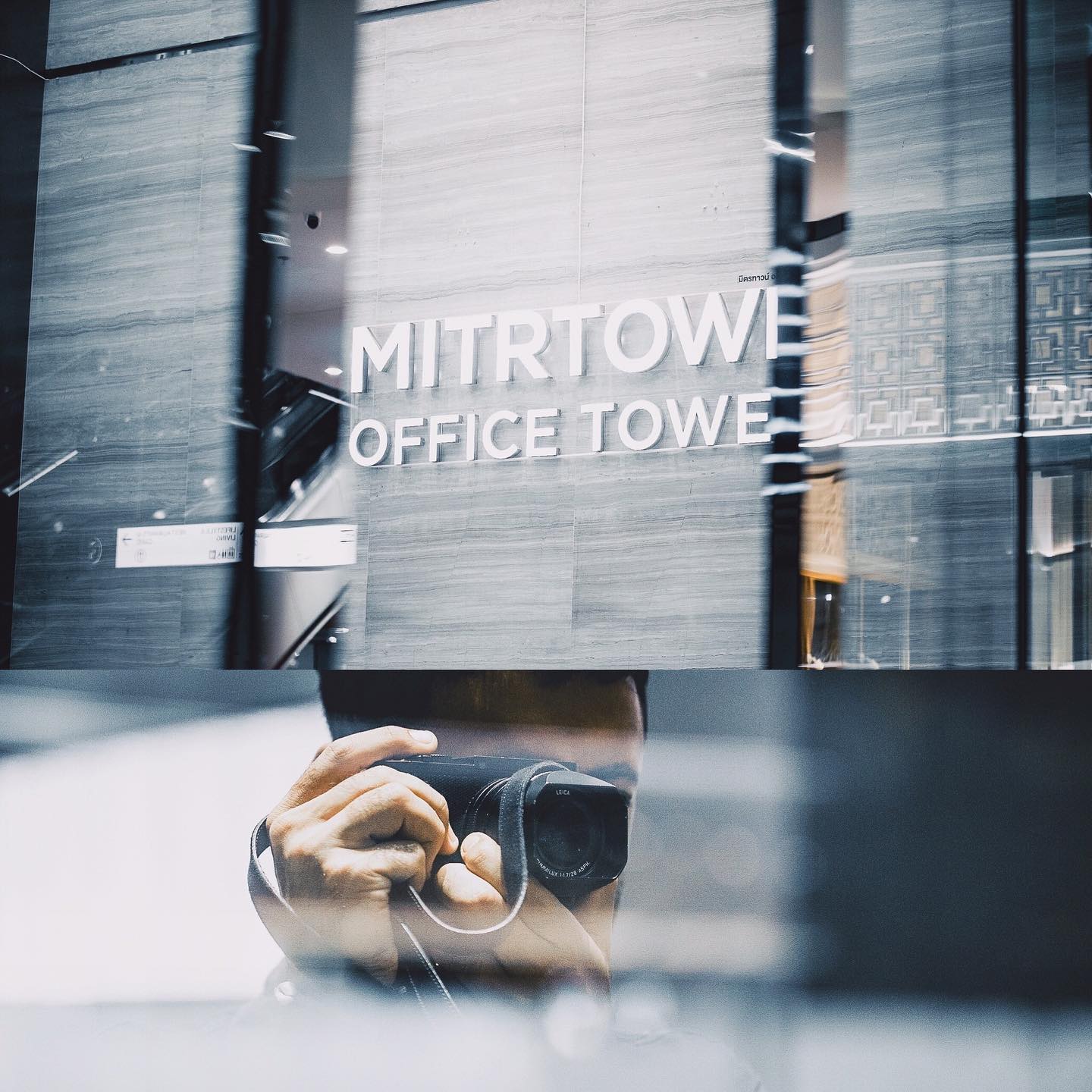 A person takes a photo with a Leica camera in front of the Mitrtown Office Tower in an urban setting.