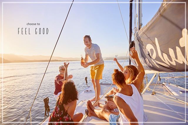 A group of friends enjoying a celebratory boat trip out on the ocean during sunset.